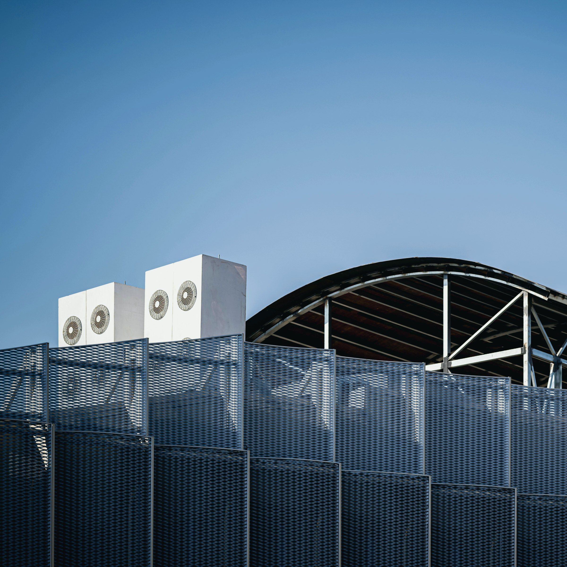 Groupes de climatisation en toiture d'un bâtiment à façade en métal déployé