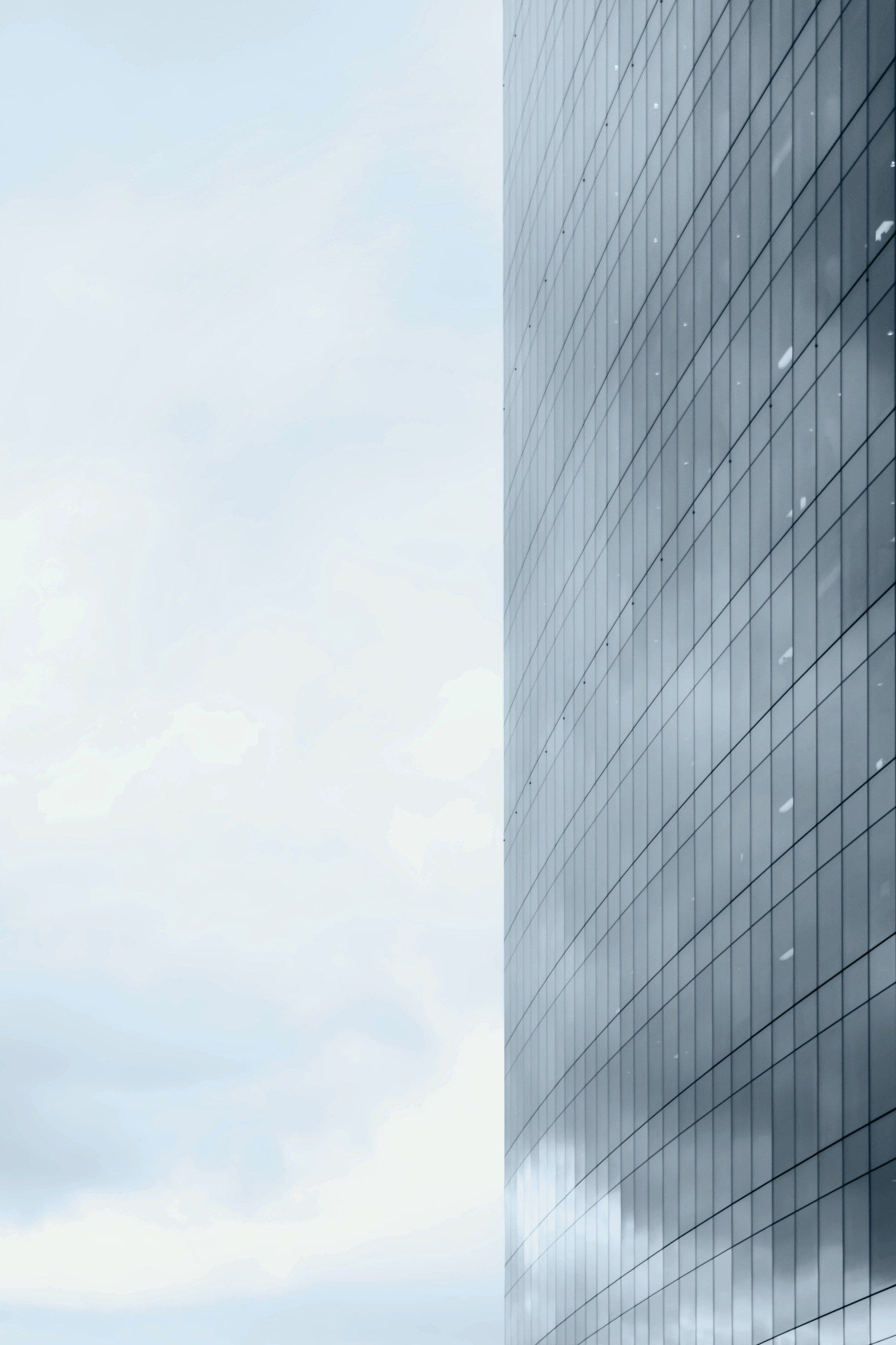 Façade vitrée d'une tour de bureaux sous un ciel clair