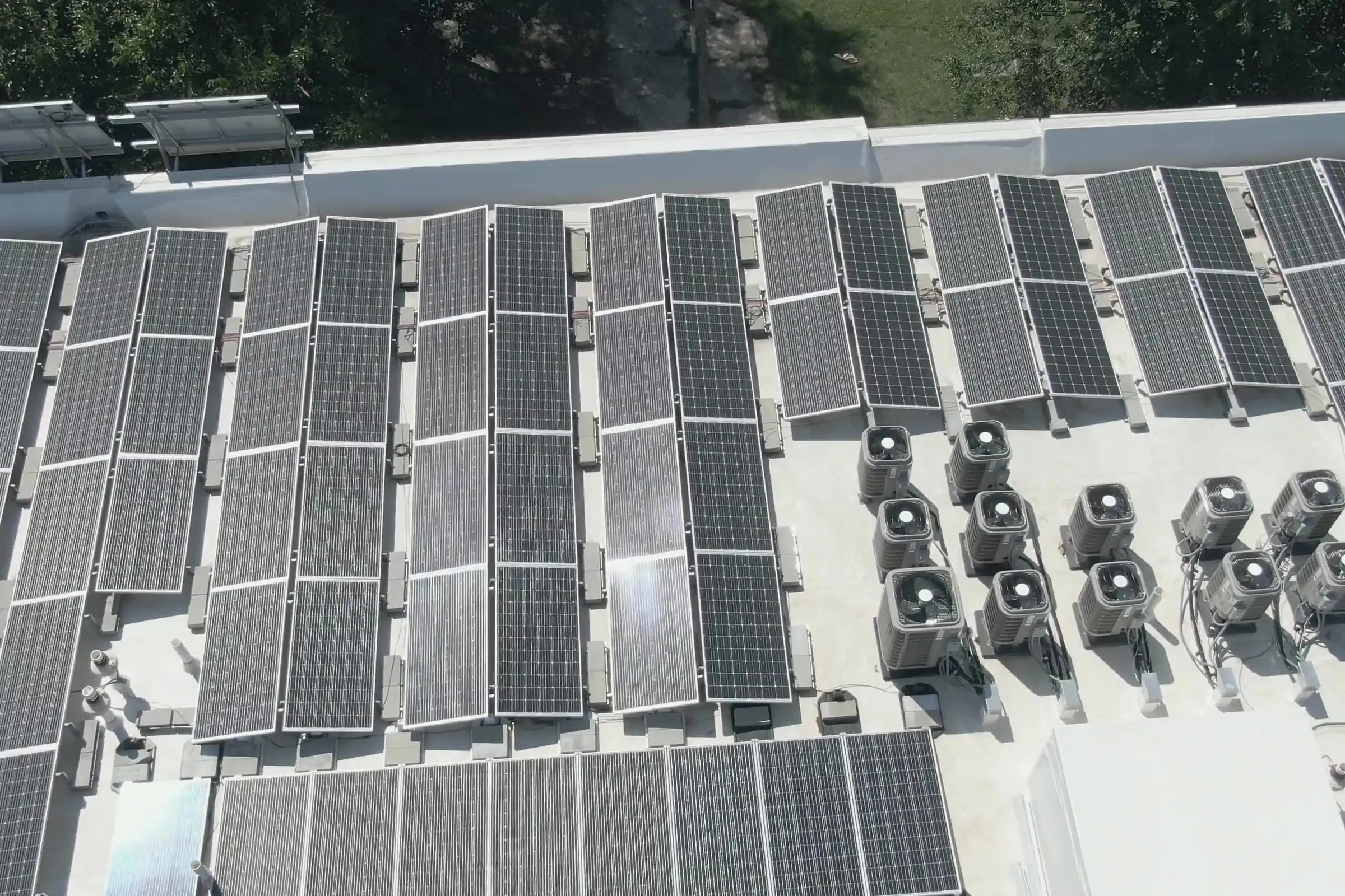Groupes extérieurs de pompes à chaleur parmi des panneaux solaires en toiture