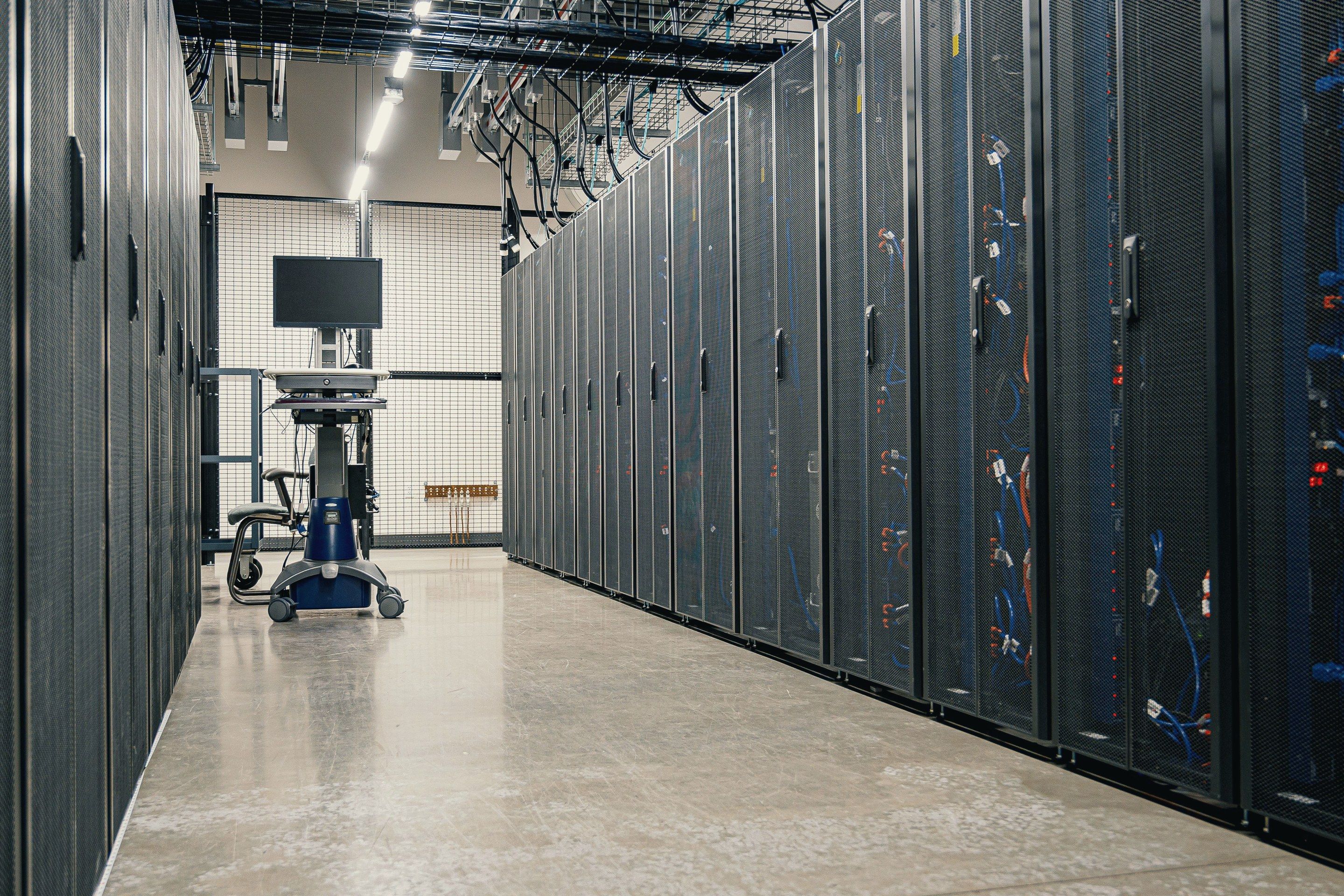 Allée de baies informatiques dans une salle serveurs (illustration)